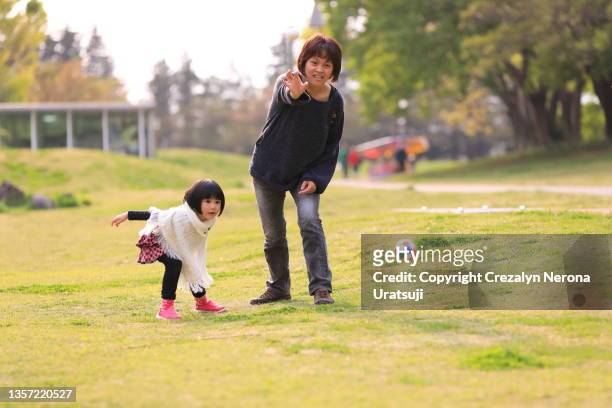 enjoying day off,mother and child playing with sports ball at the public park - play off stock pictures, royalty-free photos & images