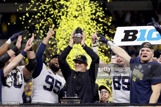 Head coach Jim Harbaugh of the Michigan Wolverines celebrates with the trophy after the Michigan Wolverines defeated the Iowa Hawkeyes 42-3 to win...