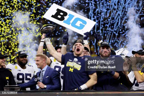 Aidan Hutchinson of the Michigan Wolverines celebrates with the trophy after the Michigan Wolverines defeated the Iowa Hawkeyes 42-3 to win the Big...