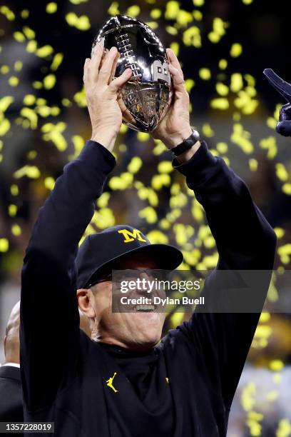 Head coach Jim Harbaugh of the Michigan Wolverines celebrates with the trophy after the Michigan Wolverines defeated the Iowa Hawkeyes 42-3 to win...