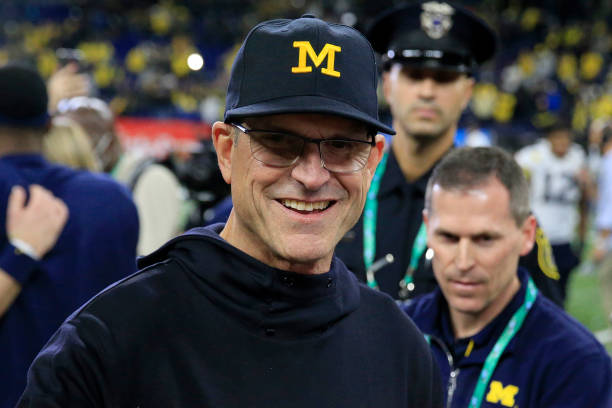 Head coach Jim Harbaugh of the Michigan Wolverines walks on the field after winning the Big Ten Football Championship game against the the Iowa...
