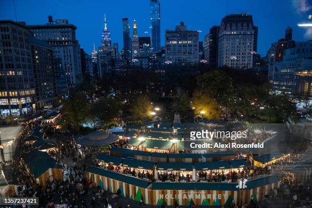 Large crowds of people with and without masks visit the Holiday Market in Union Square on December 04, 2021 in New York City. The holiday season is...