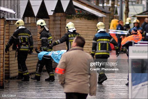 Firemen stretcher off a victim after a grenade attack at Place St-Lambert in the heart of the city on December 13, 2011 in Liege, Belgium. Two people...