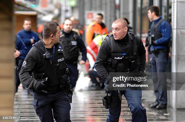 Police run with unholstered guns after a grenade attack at Place St-Lambert in the heart of the city on December 13, 2011 in Liege, Belgium. Two...