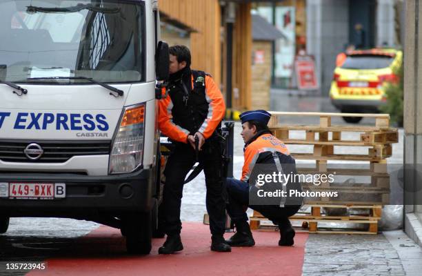 Armed police shield themselves behind a van after a grenade attack at Place St-Lambert in the heart of the city on December 13, 2011 in Liege,...