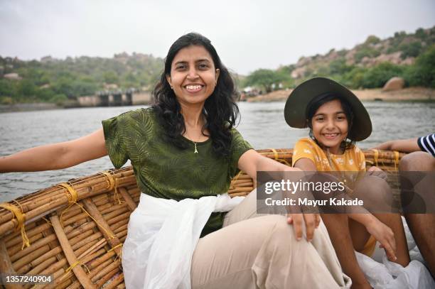 mother and daughter enjoying a coracle ride at hampi, karnataka - indian family vacation stock pictures, royalty-free photos & images