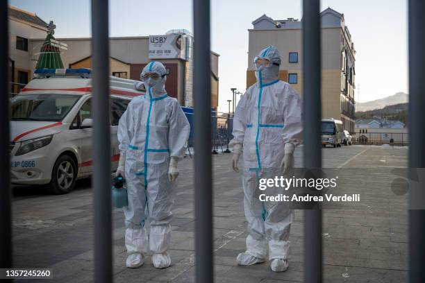 Medical workers wearing PPE stand behind a closed gate inside an area restricted to the general people at Prince Ski Town on December 05, 2021 in...