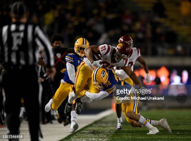 Kyle Ford of the USC Trojans gets tackled by Daniel Scott of the California Golden Bears at California Memorial Stadium on December 04, 2021 in...