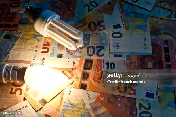 electric bulbs + euro bank notes - inflation euro stock-fotos und bilder