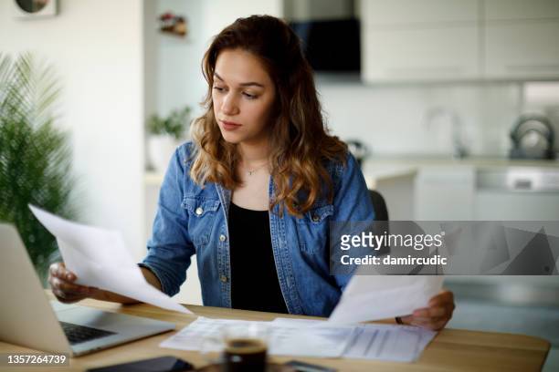 serious young woman working at home - documentos imagens e fotografias de stock
