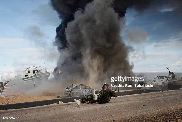 Rebel soldier fighting against Col. Muammar Gaddafi lies on the ground after government forces dropped shells at the frontline March 9, 2011 near Ras...