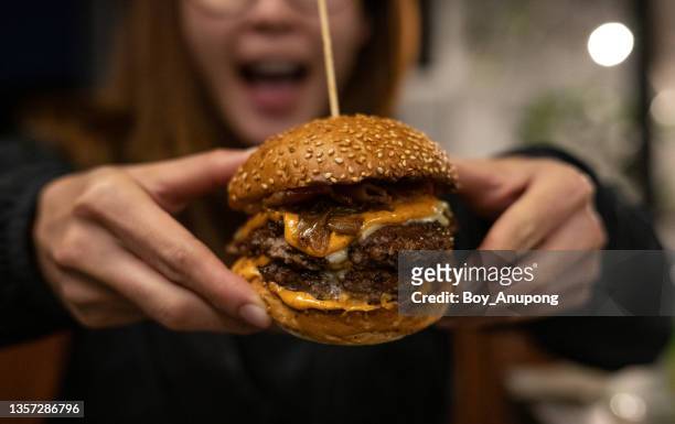 close up of woman opened her mouth, ready to eat a double beef cheeseburger. - giant cheeseburger stock pictures, royalty-free photos & images