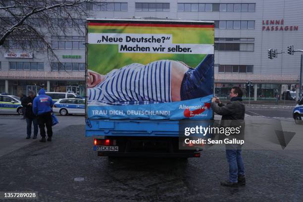 Member of the right-wing Alternative for Germany political party secures an AfD truck with a banner that read: "New Germans? We'll make them...