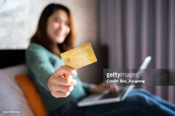 close up of woman holding credit card in her hand while doing shopping online on laptop. - people showing respect stock pictures, royalty-free photos & images