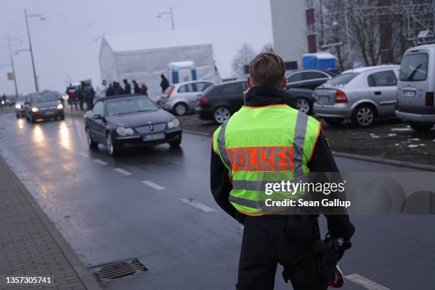 Policeman monitors incoming vehicles arriving from Poland near the Slubice border crossing on December 05, 2021 in Frankfurt an der Oder, Germany....