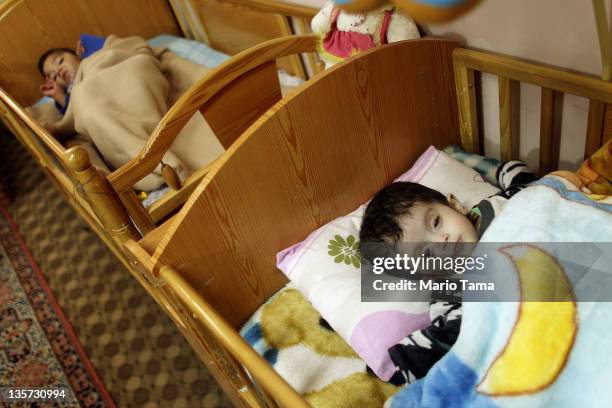Disabled orphan Rasha rests in the orphanage where she lives on December 13, 2011 in Baghdad, Iraq. Rasha was abandoned at birth by her parents at...