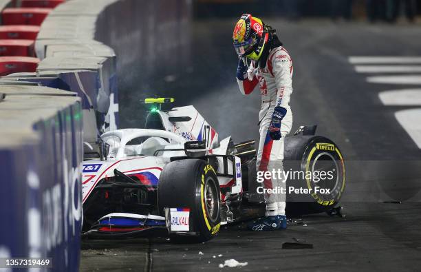 Mick Schumacher of Germany driving the Haas F1 Team VF-21 Ferrari climbs from his car after crashing during the F1 Grand Prix of Saudi Arabia at...