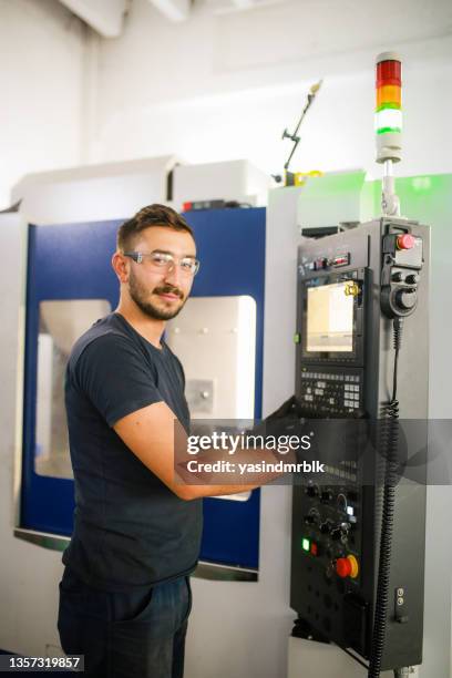 mechanical technician worker at modern cnc metal machining milling center in tool workshopclick on banner below to view more images in the.  
young entrepreneur cnc machine in background - cnc stock pictures, royalty-free photos & images