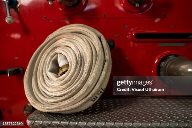 fire hose on the bumper of the fire truck. - firefighter's helmet stock pictures, royalty-free photos & images