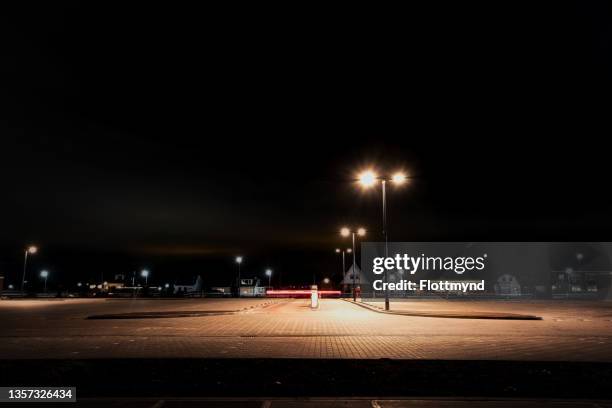 empty parking lot with barrier and lots of space for next day customers or employees - empty lot night stock-fotos und bilder