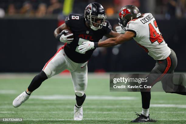 Kyle Pitts of the Atlanta Falcons carries the ball after a reception as Ross Cockrell of the Tampa Bay Buccaneers defends during the second quarter...