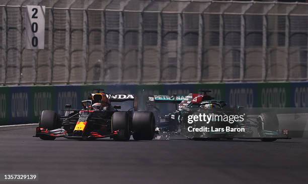 Max Verstappen of the Netherlands driving the Red Bull Racing RB16B Honda and Lewis Hamilton of Great Britain driving the Mercedes AMG Petronas F1...