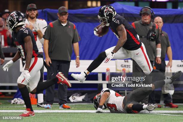 Kyle Pitts of the Atlanta Falcons jumps over Ross Cockrell of the Tampa Bay Buccaneers after a reception during the second quarter at Mercedes-Benz...