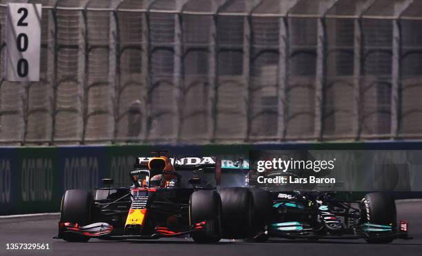 Max Verstappen of the Netherlands driving the Red Bull Racing RB16B Honda and Lewis Hamilton of Great Britain driving the Mercedes AMG Petronas F1...