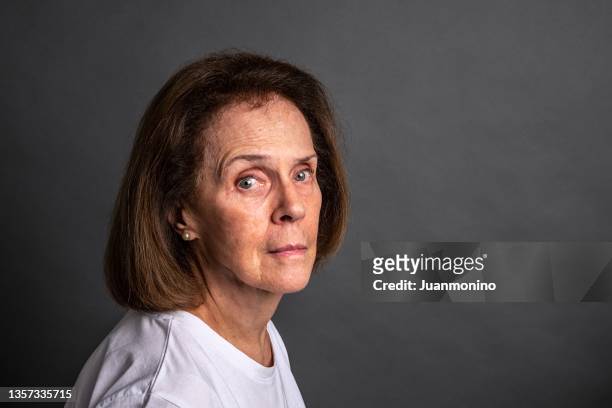 serious senior woman looking at the camera - studio shot lonely woman stock pictures, royalty-free photos & images