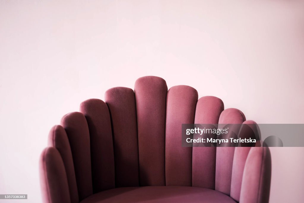 Pink textured velor armchair on a pink background.