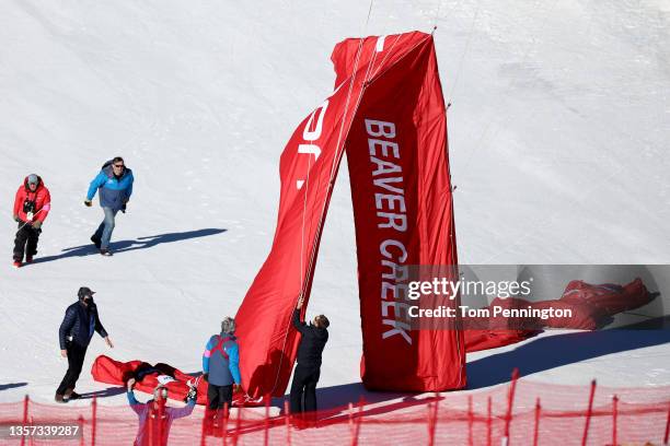 Course workers remove an inflatable finish line arch due to high winds prior to the cancellation of the Men's Downhill during the Audi FIS Alpine Ski...