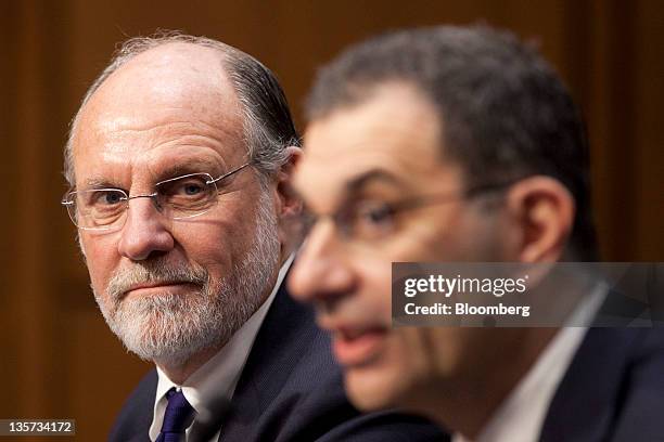 Jon S. Corzine, former chairman and chief executive officer of MF Global Holdings Ltd., left, listens as Bradley Abelow, president and chief...