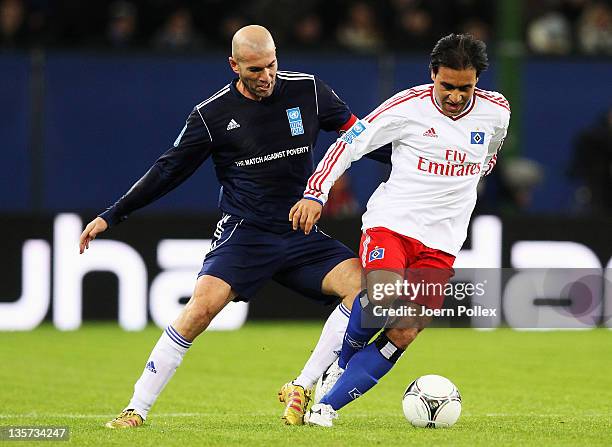 Mehdi Madavikia of the team HSV Allstars and Zinedine Zidane of the team Ronaldo, Zidane & Friends battle for the ball during the 'Match Against...