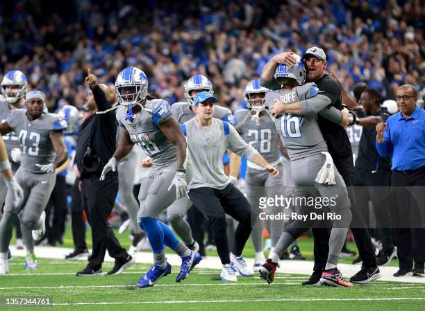 Jared Goff of the Detroit Lions celebrates with head coach Dan Campbell after defeating the Minnesota Vikings 29-27 to win their first game of the...