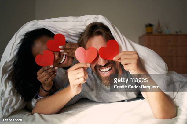 young happy couple in bed - valentines day stock pictures, royalty-free photos & images