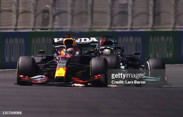 Max Verstappen of the Netherlands driving the Red Bull Racing RB16B Honda and Lewis Hamilton of Great Britain driving the Mercedes AMG Petronas F1...