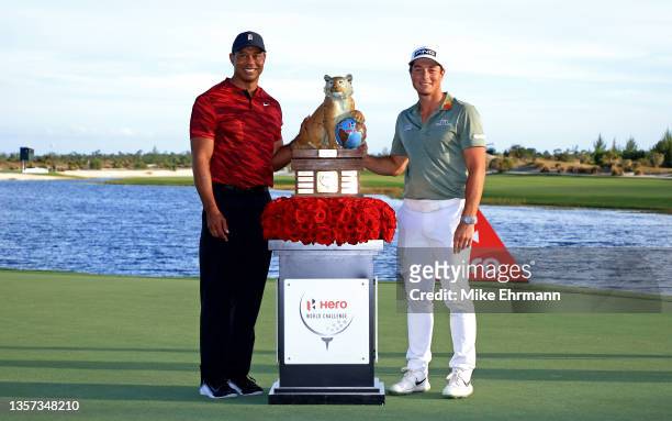 Tiger Woods of the United States poses with Viktor Hovland of Norway and the trophy after winning the Hero World Challenge at Albany Golf Course on...