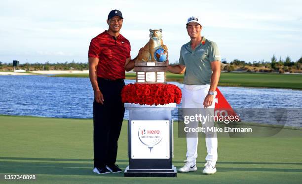 Tiger Woods of the United States poses with Viktor Hovland of Norway and the trophy after winning the Hero World Challenge at Albany Golf Course on...