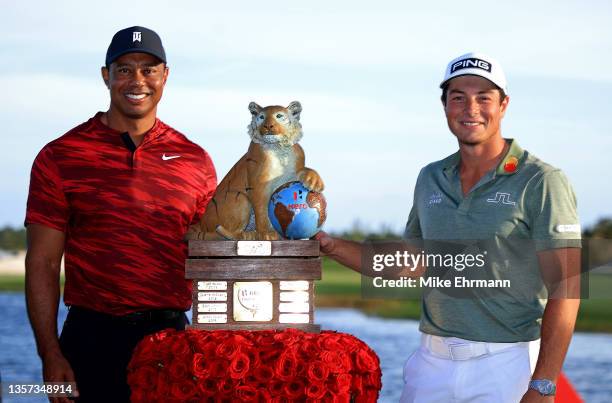 Tiger Woods of the United States poses with Viktor Hovland of Norway and the trophy after winning the Hero World Challenge at Albany Golf Course on...