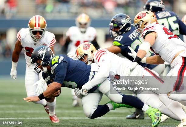 Russell Wilson of the Seattle Seahawks is sacked by Arik Armstead of the San Francisco 49ers during the first quarter at Lumen Field on December 05,...