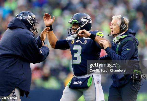 Russell Wilson of the Seattle Seahawks celebrates a touchdown throw with head coach Pete Carroll during the third quarter against the San Francisco...