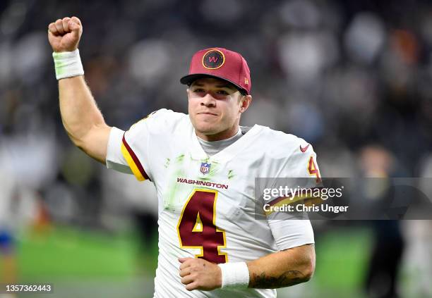 Taylor Heinicke of the Washington Football Team holds up his fist as he jogs off the field after the game against the Las Vegas Raiders at Allegiant...