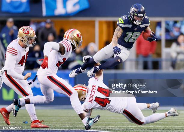 Freddie Swain of the Seattle Seahawks jumps over Kyle Juszczyk of the San Francisco 49ers on a return play during the fourth quarter at Lumen Field...