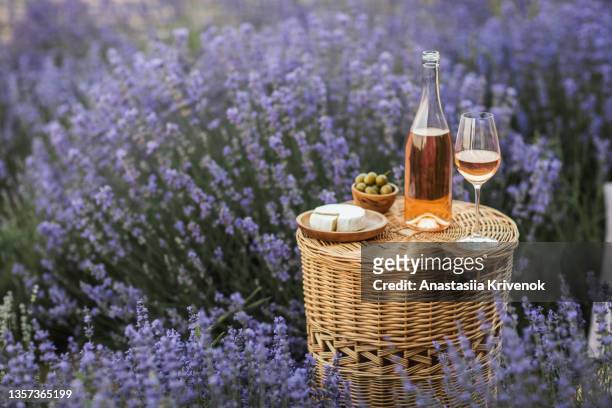 wicker basket tea table with rose wine in lavender field. - provence alpes cote d'azur stock-fotos und bilder