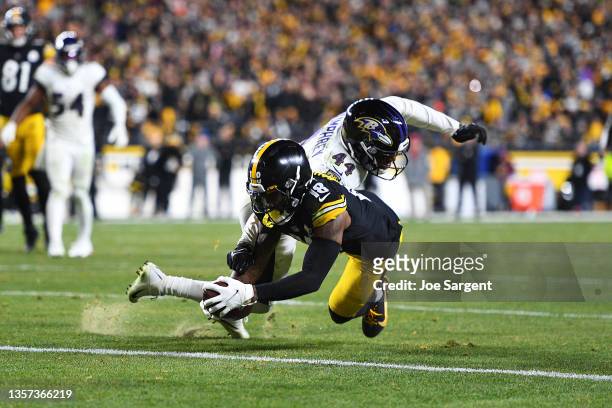 Diontae Johnson of the Pittsburgh Steelers dives for a touchdown as Marlon Humphrey of the Baltimore Ravens defends during the fourth quarter at...