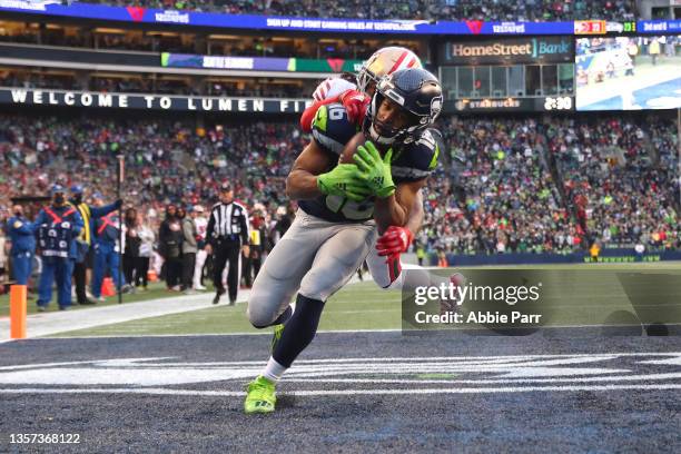 Tyler Lockett of the Seattle Seahawks catches a pass against Josh Norman of the San Francisco 49ers for a touchdown during the third quarter at Lumen...