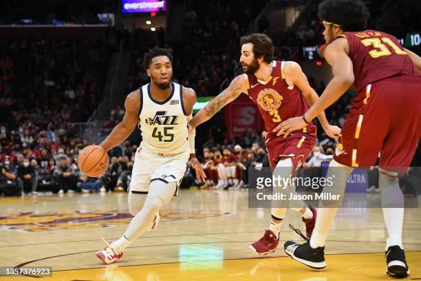 Donovan Mitchell of the Utah Jazz drives to the basket around Ricky Rubio and Jarrett Allen of the Cleveland Cavaliers during the fourth quarter at...