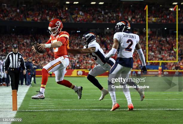 Patrick Mahomes of the Kansas City Chiefs crosses the goal line for a touchdown as Kyle Fuller and Pat Surtain II of the Denver Broncos defend during...