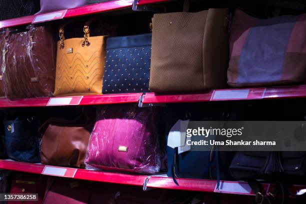 ladies hand bags kept on the shelves in a shopping mall for sale. - designer bag stock pictures, royalty-free photos & images