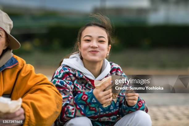 young people and their teacher practicing street dance in a park by the beach. - trends asian stock-fotos und bilder